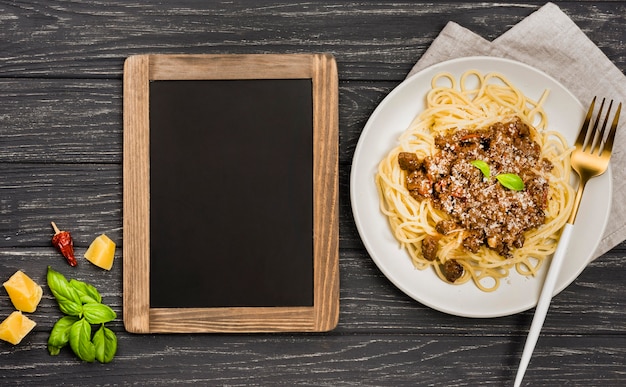 Chalkboard beside plate with spaghetii bolognese