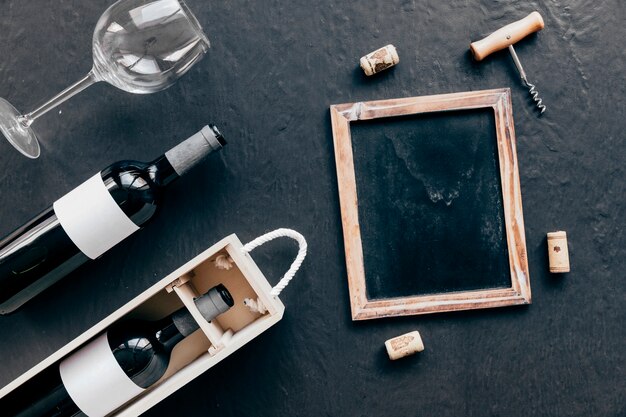 Chalkboard and corkscrew with corks near wine