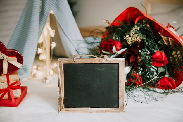 Chalkboard near bouquet and pile of presents