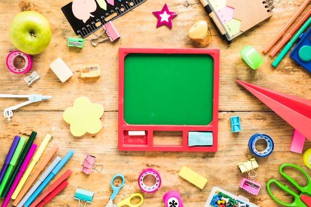 Chalkboard surrounded by stationery objects 