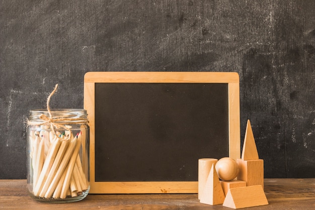 Chalkboard with drawing pens and wooden shapes