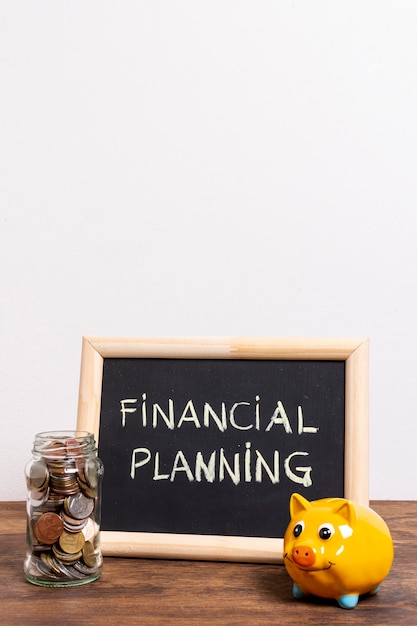 財務計画テキストと貯金箱のある黒板