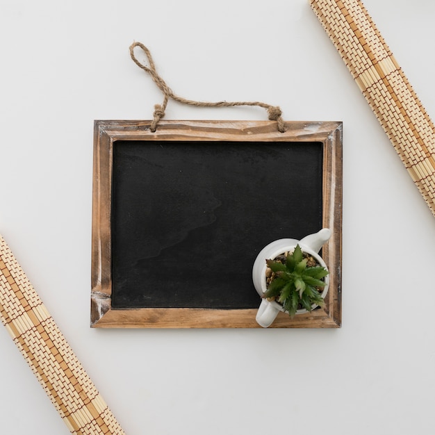 Chalkboard with flower pot on top