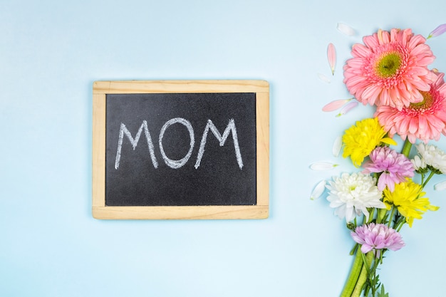 Free photo chalkboard with mom title near bunch of fresh bright flowers