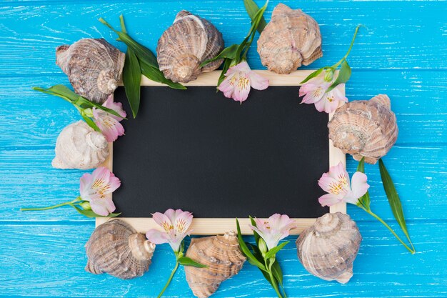 Chalkboard with plant leaves and flowers on desk