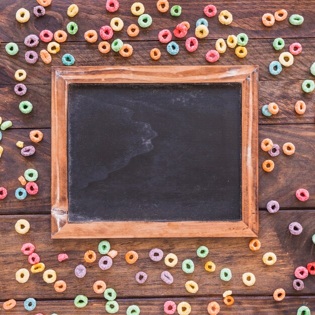 Chalkboard with scattered cereals on table 