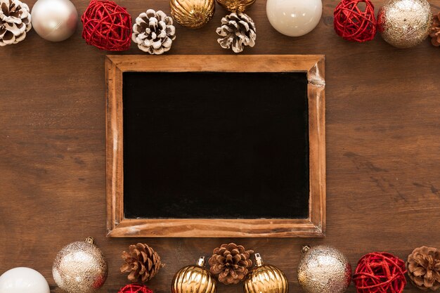 Chalkboard with shiny baubles on table 