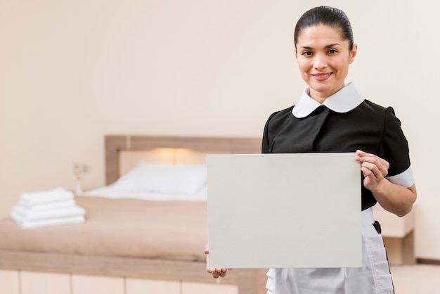 Chambermaid in hotel room with laptop