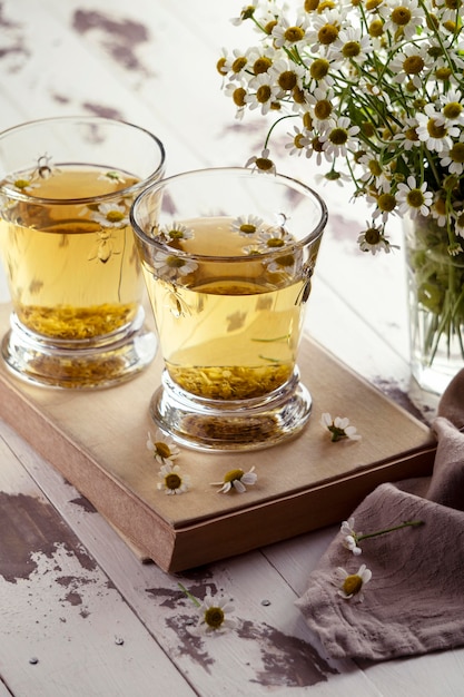 Chamomile tea cups on wooden board