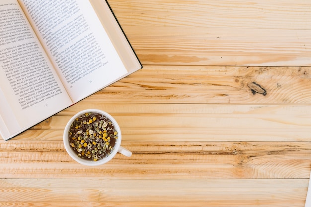 Chamomile tea near opened book