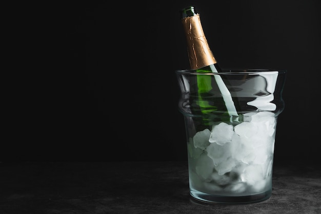 Бутылка шампанского в ведерке со льдом с копией пространства