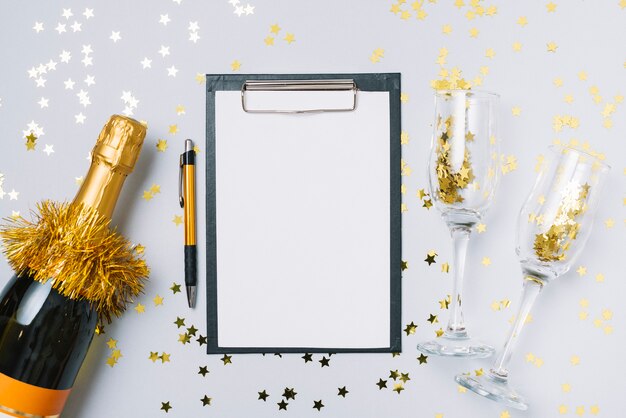 Champagne bottle with clipboard on table 