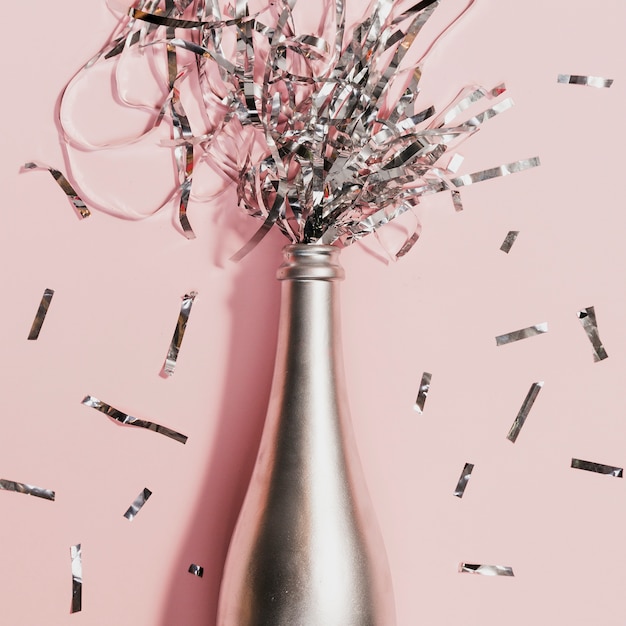 Free photo champagne bottle with confetti at new years party