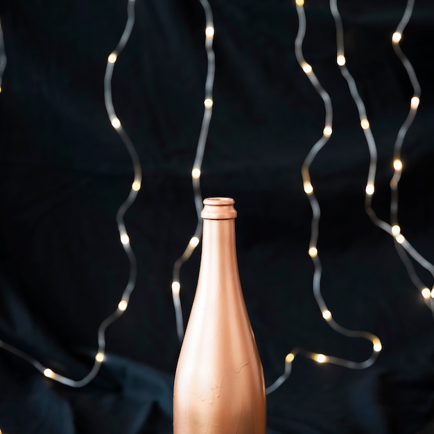 Free photo champagne bottle with garland