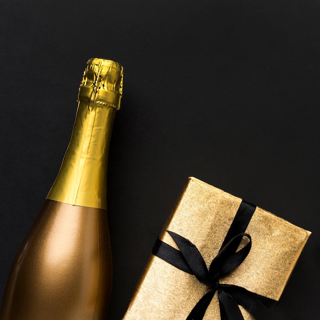 Foto gratuita bottiglia di champagne con regalo