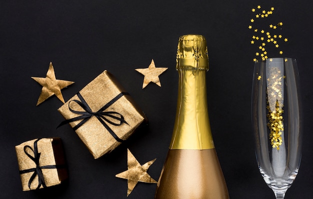 Champagne bottle with glass and gifts