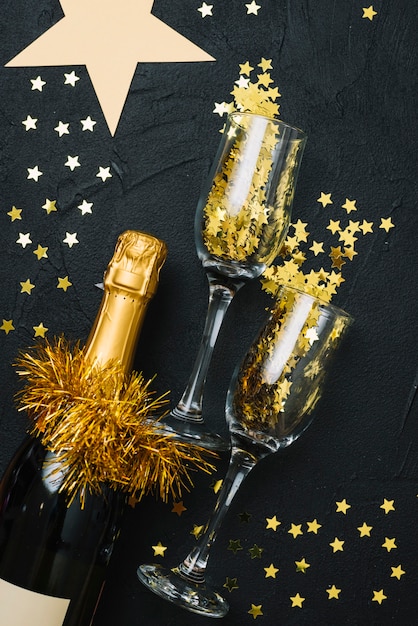 Champagne bottle with glasses on black table