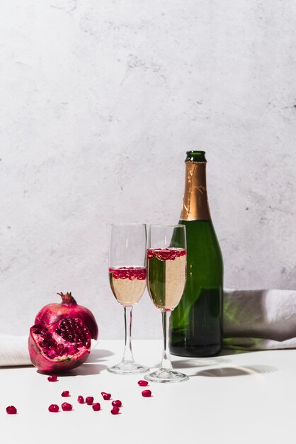 Champagne bottle with glasses and pomegranate