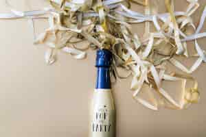 Foto gratuita bottiglia di champagne con nastri sul tavolo