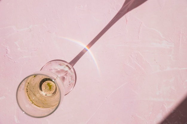 Foto gratuita bicchiere di champagne sul tavolo rosa