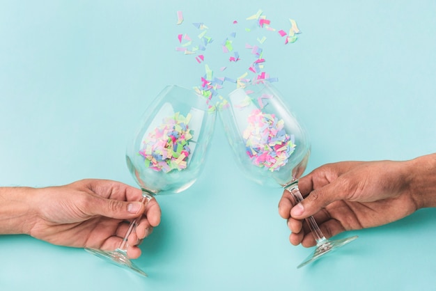 Free photo champagne glasses clashing and confetti