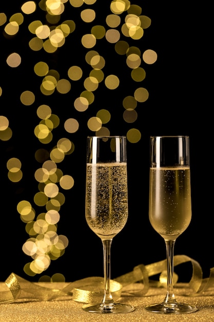 Foto gratuita bicchieri di champagne con luci bokeh