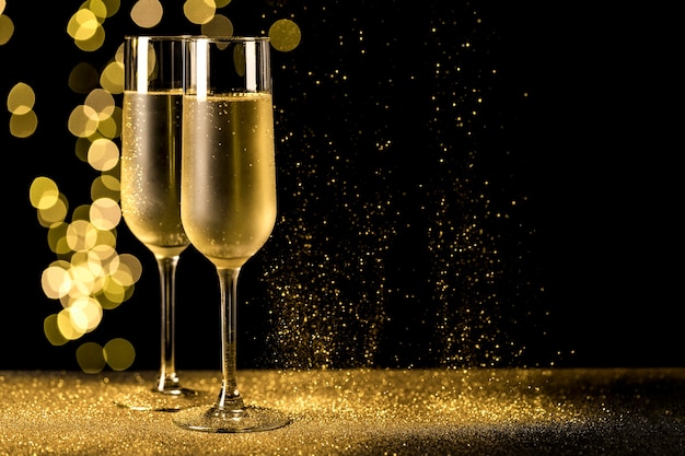 Free photo champagne glasses with bokeh lights