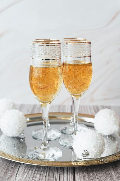 Champagne glasses with christmas balls on a tray