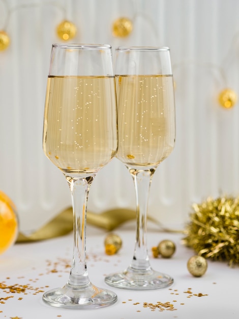 Foto gratuita bicchieri di champagne con tinsel dorato