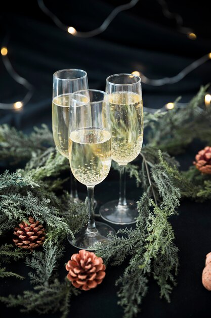 Champagne glasses with green branches on table