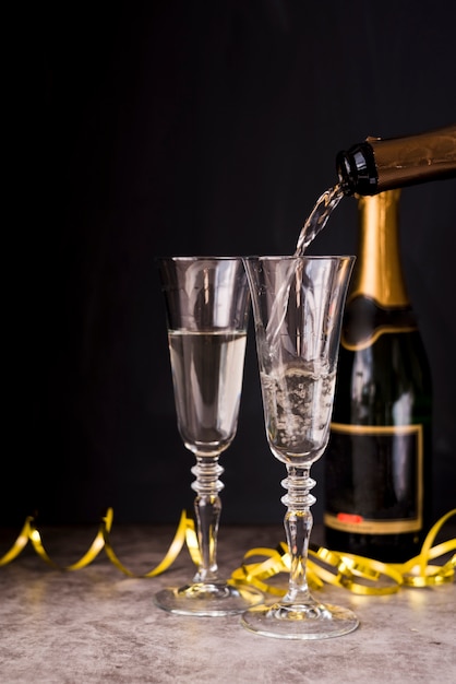 Champagne pouring into the glass with streamers at party