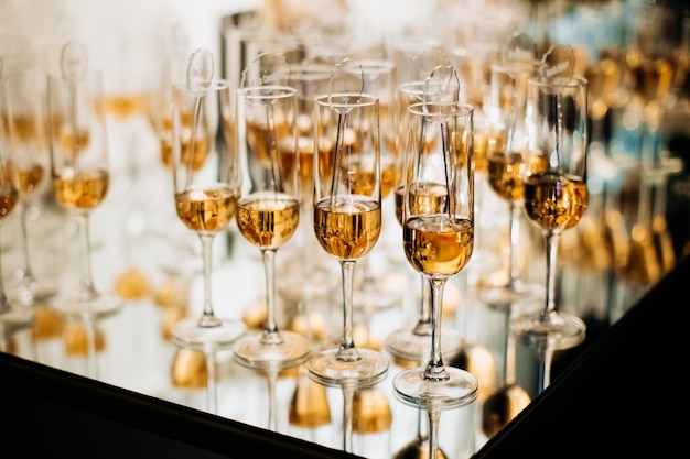 Бесплатное фото Шампанское на подносе с алкогольными напитками и зеркальным отражением