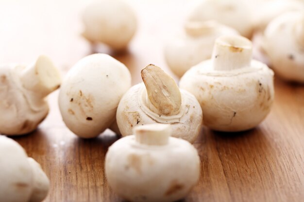 Champignons on wooden surface