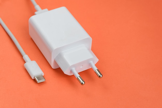 Зарядное устройство и USB-кабель типа C на красном фоне
