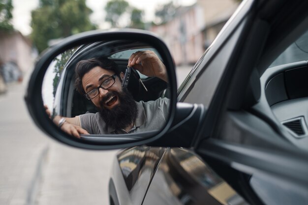 車のキーを保持しているカリスマ的な男