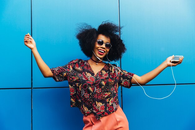 Charming amazing afro american young woman in sunglasses, dancing 