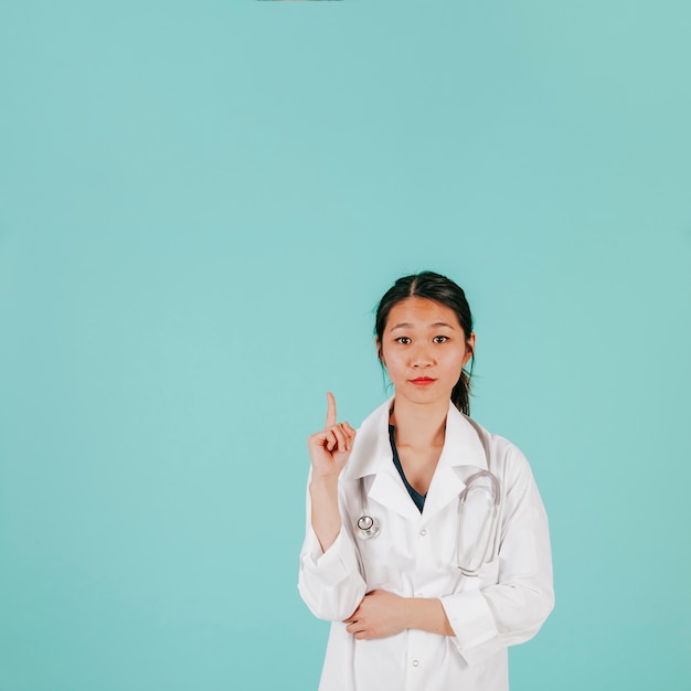 Free photo charming asian doctor pointing up