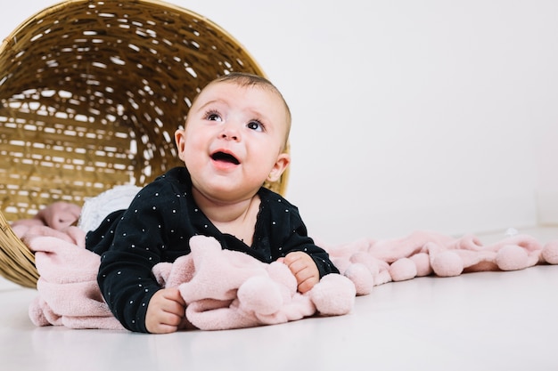 Bambino affascinante sulle coperte vicino al canestro