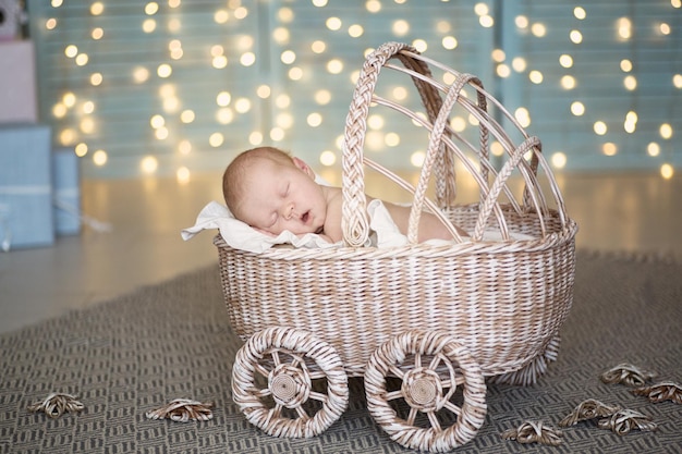 Бесплатное фото Очаровательная малышка спит в плетеной коляске кремового цвета