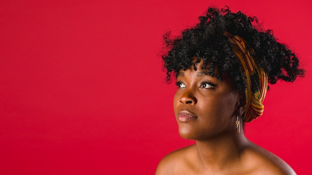 Charming bare black young woman on colored background