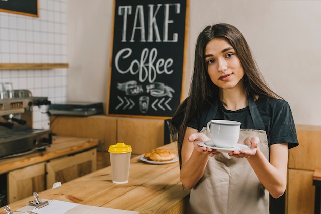 Foto gratuita barista affascinante che offre bevande calde