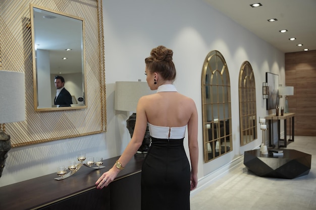 Charming beautiful girl standing on looking at the mirror