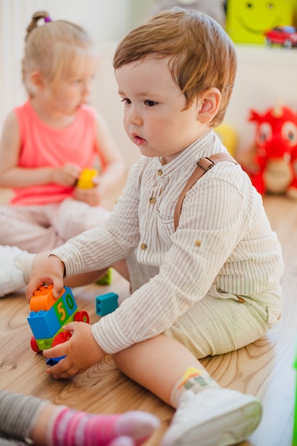 Charming boy in kindergarten with other kids