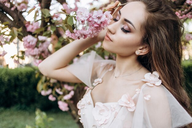 The charming bride stands in the park