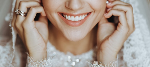 Charming bride with perfect skin touches her earring tender