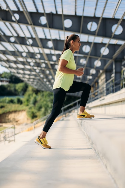 Free photo charming brunette doing endurance exercises on stairs