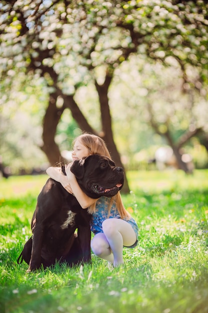 Очаровательный ребенок, обнимающий черную собаку