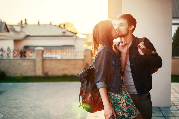 デニムジャケットが夕日にキスを持つ魅力的なカップル