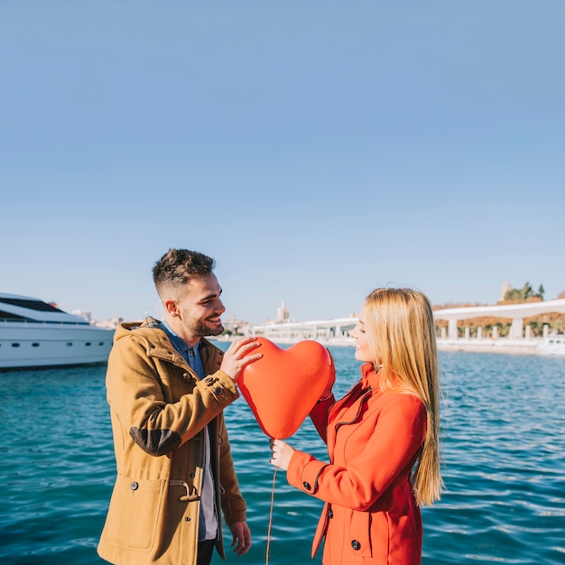 Charming couple with romantic balloon outside