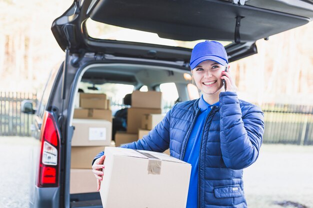 Charming delivery girl having phone call